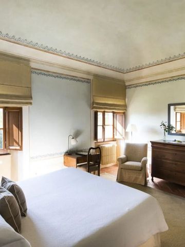 Geräumiges Zimmer in warmen Tönen mit Bett und antikem Schreibtisch.