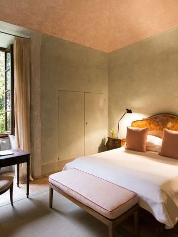 Gemütliches Zimmer mit Bett und Blick auf grünen Garten.