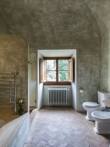 Rustikales Badezimmer mit Badewanne und Blick auf den Garten