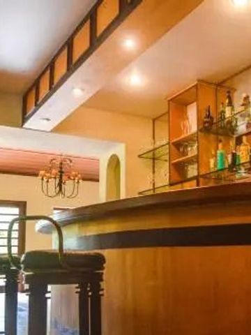 Elegante Hotelbar mit stilvollen Hockern und dekorativen Spirituosenregalen