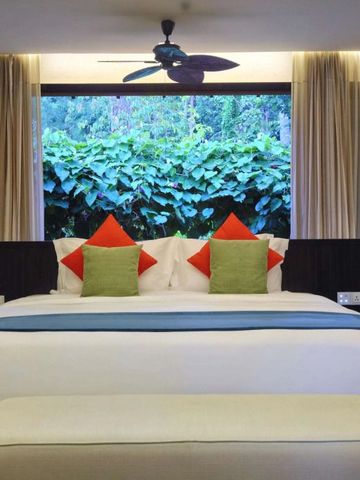 Gemütliches Schlafzimmer mit großen Fenstern und Gartenblick