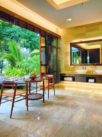 Luxuriöses Badezimmer mit Blick auf tropische Pflanzen und eleganter Einrichtung