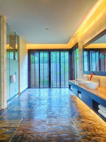 Modernes Badezimmer mit großem Spiegel und Natursteinfliesen mit Gartenblick.