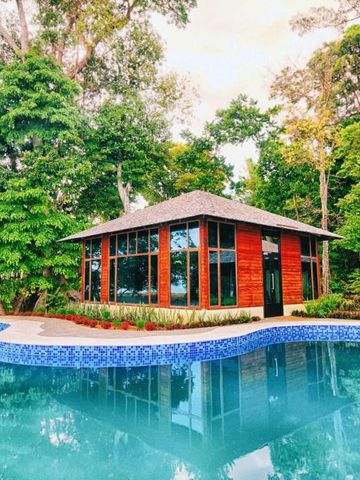 Exklusive Villa am Pool umgeben von üppiger tropischer Vegetation.