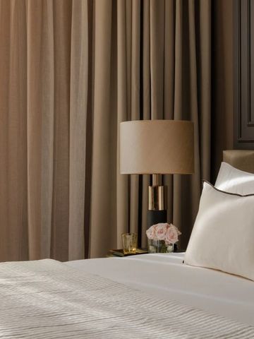 Elegantes Hotelzimmer mit luxuriöser Bettwäsche und sanfter Beleuchtung.