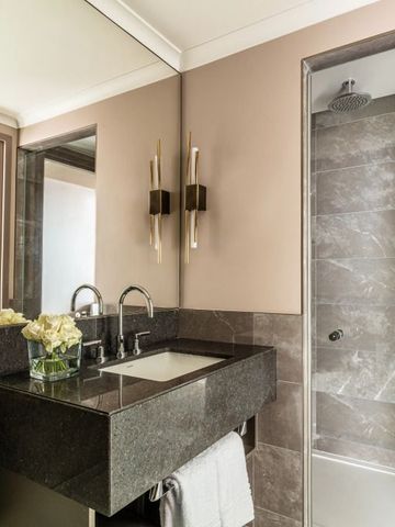 Modernes Badezimmer mit Marmordetails und großzügiger Dusche.