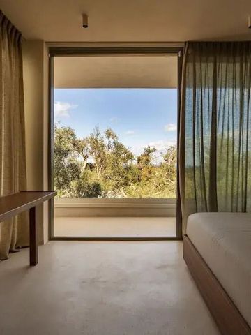 Helles Schlafzimmer mit Blick auf die Natur durch große Fenster