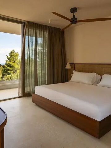 Komfortables Schlafzimmer mit großen Fenstern und Naturblick