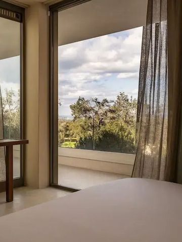 Schlafzimmer mit Fensterfront, die eine malerische Landschaft zeigt