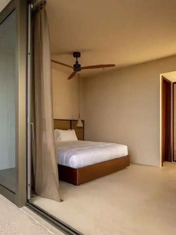 Helles Zimmer mit Bett und großen Glasfenstern