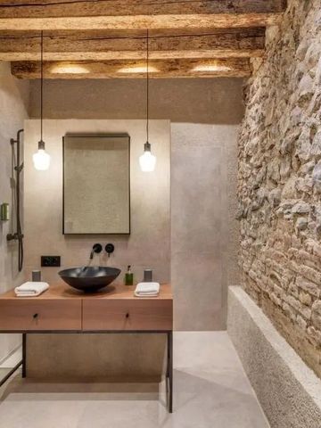 Stilvolles Badezimmer mit Natursteinwand und Holzbalkendecke