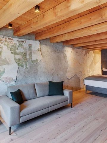 Großzügiges Hotelzimmer mit Sofa und Holzbalkendecke