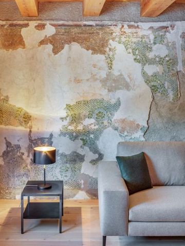 Detailreiche Wandgestaltung mit rustikalem Charme neben einer bequemen Couch.