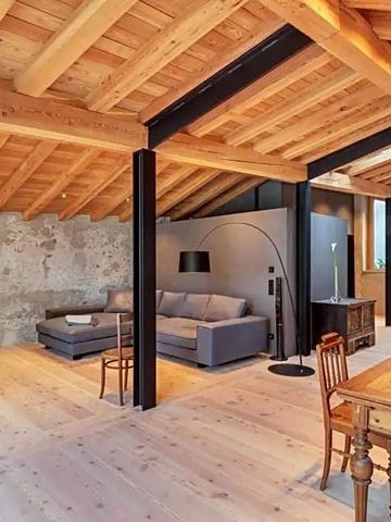 Geräumiger Wohnbereich mit stilvollem Holzboden und gemütlichem Sofa.