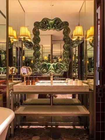 Stilvolles Badezimmer mit großem Spiegel und eleganter Beleuchtung.