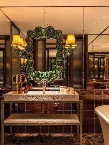 Badezimmer mit dekorativem Spiegel und ruhiger Farbgebung.