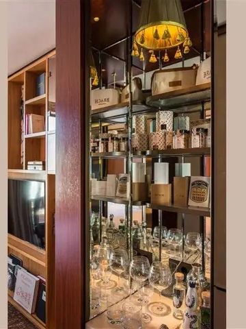 Elegantes Regal mit dekorativen Gläsern und Parfumflakons in einem Hotelzimmer.