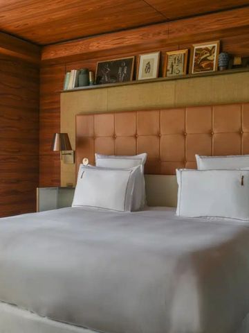 Komfortables Hotelzimmer mit Holzwänden und großem Bett im Brach Paris