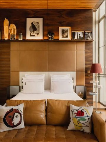 Gemütliches Zimmer mit Kunst an den Wänden und Ledersofa im Brach Paris