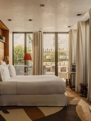 Geräumiges Hotelzimmer mit moderner Einrichtung und großer Fensterfront im Brach Paris