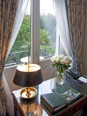 Eleganter Schreibtisch mit Blick auf den grünen Garten durch ein großes Fenster