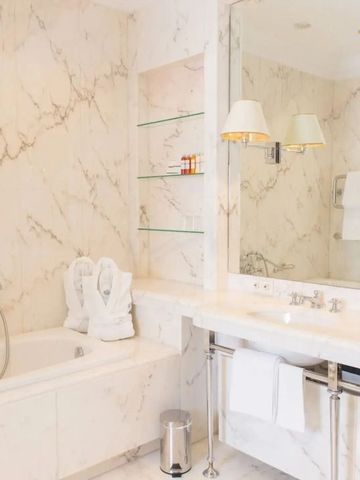 Luxuriöses Badezimmer mit Marmorverkleidung und großer Badewanne