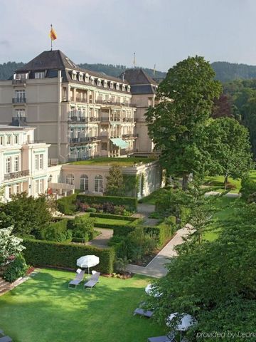 Rückseite des Brenners Park-Hotel mit gepflegtem Garten und Liegestühlen