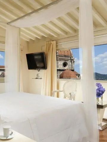 Himmelbett in lichtdurchflutetem Raum mit Aussicht auf den Dom von Florenz
