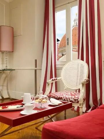 Wohnbereich mit roten Akzenten und Blick auf den Dom durch das Fenster