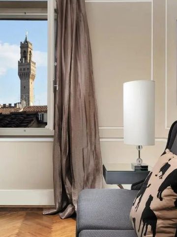 Zimmer mit Fensterblick auf einen Turm und stilvoller Inneneinrichtung