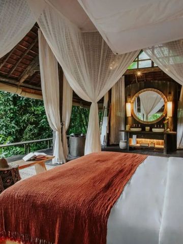 Offenes Schlafzimmer mit Himmelbett und Blick auf den Dschungel im Buahan a Banyan Tree Escape