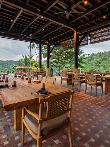 Offenes Restaurant mit Holztischen und Blick auf den üppigen Dschungel