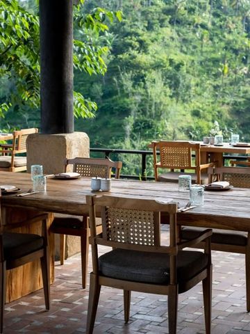 Außenessbereich mit Holzmöbeln und Ausblick auf den dichten Wald