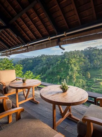 Holzmöbel auf Terrasse mit Blick auf grüne Hügellandschaft