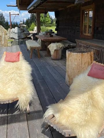 Sonnenterrasse mit Liegestühlen aus Holz und Fell