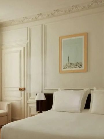 Helles Hotelzimmer mit klassischen Verzierungen und einem gemütlichen Doppelbett.