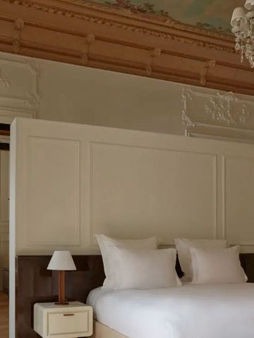 Luxuriöses Schlafzimmer mit aufwendiger Deckenverzierung und stilvoller Einrichtung.