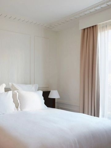 Helles Zimmer mit großem Fenster und sanftem Lichteinfall auf ein Doppelbett.