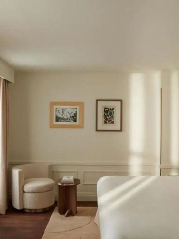 Helles Hotelzimmer mit gemütlicher Sitzecke und moderner Kunst an der Wand