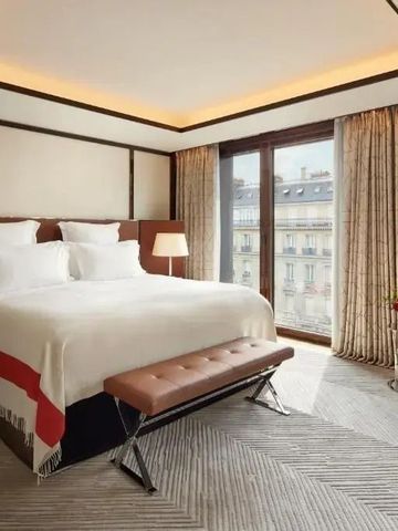 Geräumiges Zimmer mit großem Fenster und luxuriösem Bett im Bvlgari Hotel Paris