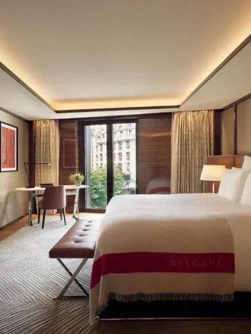Helles Zimmer mit Blick auf Paris und Kingsize-Bett im Bvlgari Hotel Paris