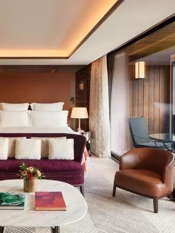 Zimmer mit gemütlichem Sofa und Zugang zu einem privaten Balkon im Bvlgari Hotel Paris.