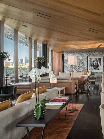 Hochwertig eingerichteter Wohnbereich mit großer Fensterfront und Stadtblick.