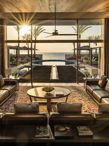 Großer Wohnbereich mit Meerblick und Sonnenuntergang von eleganten Sofas aus.