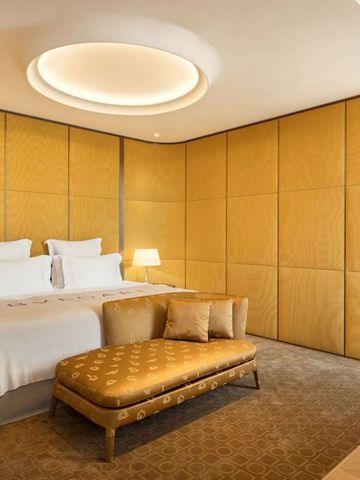 Luxuriöses Doppelbett mit eleganter Beleuchtung im Bvlgari Hotel Roma