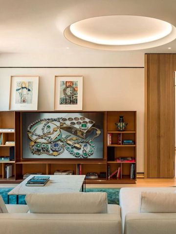 Gepflegte Lounge mit Bücherregal und moderner Kunst an den Wänden