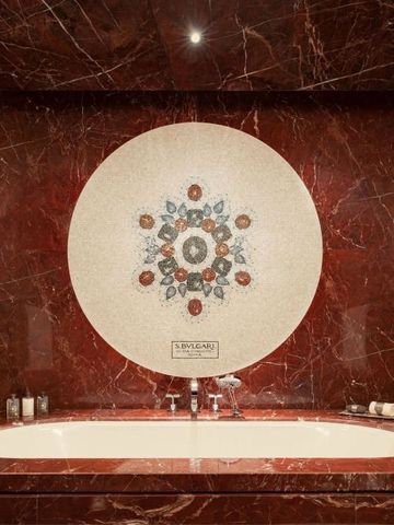 Edles Badezimmer mit rotem Marmor und kunstvoller Mosaikdekoration