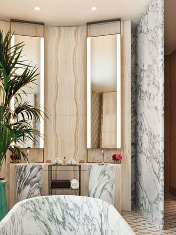 Luxuriöses Badezimmer mit Marmorakzenten und üppigem Grün