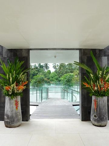 Eingang mit großen Pflanzenarrangements und Blick auf den Poolbereich