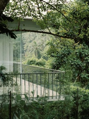 Glasveranda mit Blick auf üppige, grüne Landschaft
